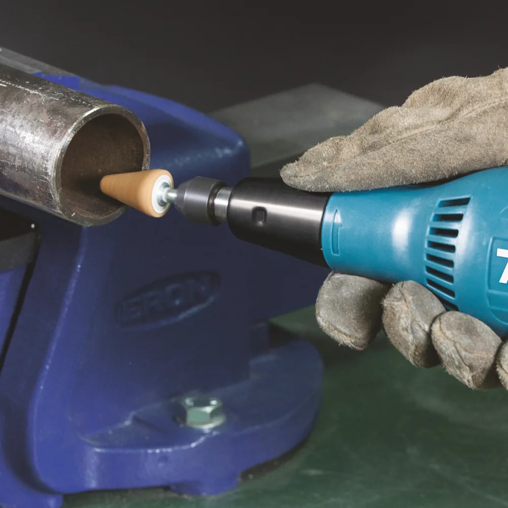 Makita GD0603 Geradschleifer beim Entgraten eines Rohrs im Schraubstock