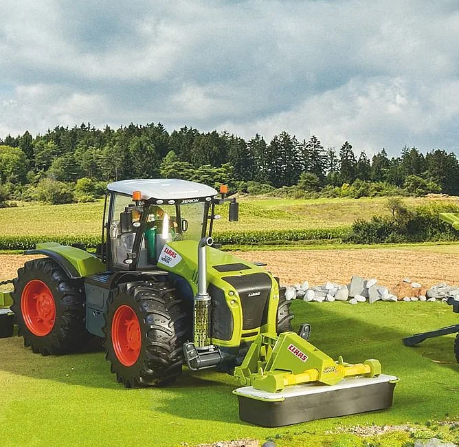 BRUDER CLAAS Disco 3050 FC Plus Frontmähwerk an einem Traktor auf der Wiese