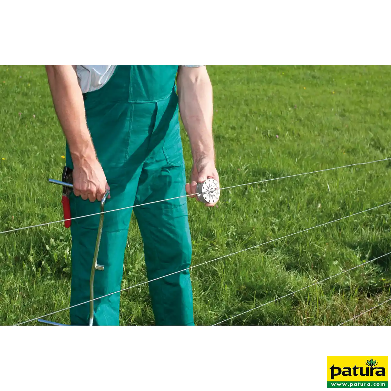 Mann setzt den rotierenden Patura Spanner am Zaundraht an