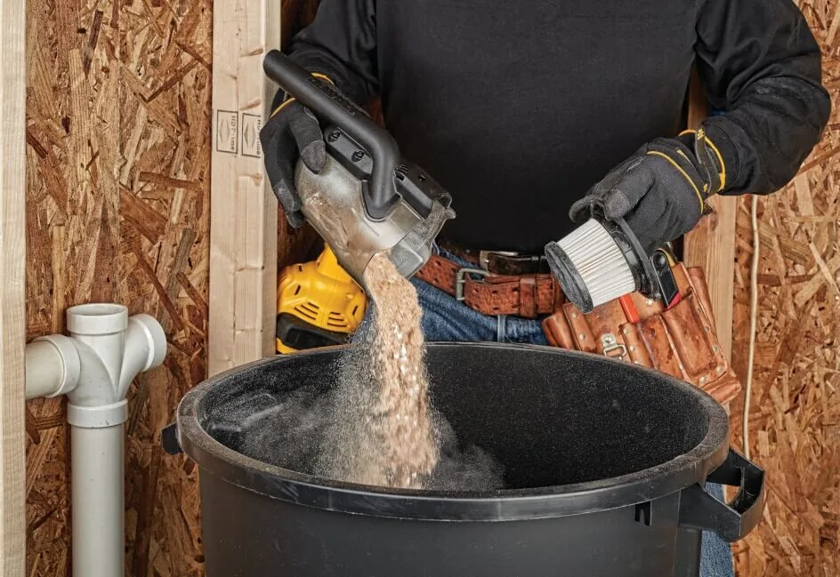 DeWalt DCV501LN Akku-Stabsauger im Einsatz, Späne werden in einen Eimer geleert